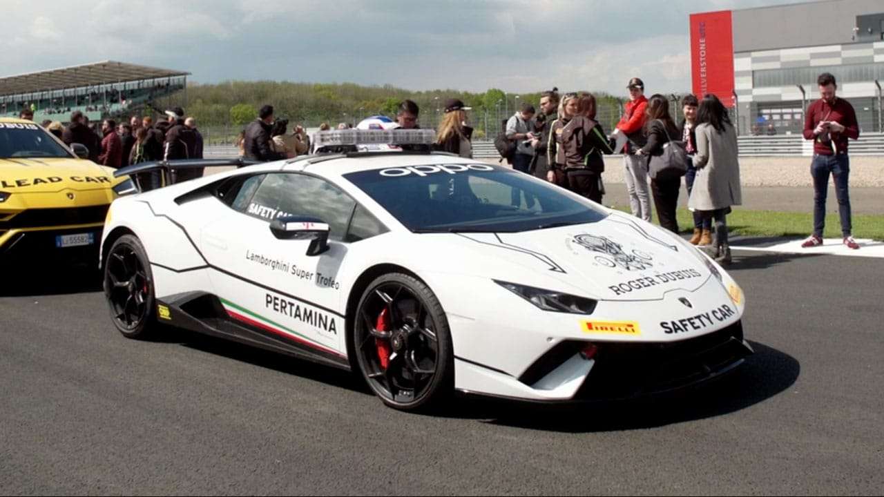A group of colleagues standing in front of a supercar at a product launch event, captured by an event videographer from Medialook